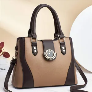 Detailed view of color-blocked leather handbag, featuring chic circular metallic clasp and dual handles.