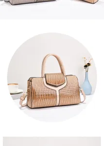 Gedetailleerd overzicht van een stijlvolle beige handtas met krokodillenprint en schouderband.