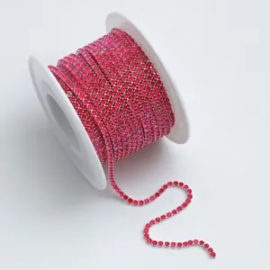 Nahaufnahme der leuchtend pinken Strass-Kette auf weißer Spule, perfekt für DIY-Handarbeiten.