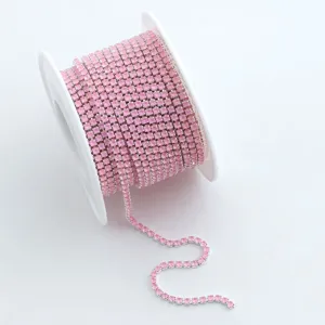 Nahaufnahme einer rosa Strass-Kette auf weißer Spule, glitzernder Kristallbesatz zum Basteln.