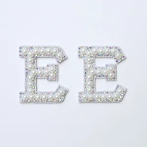 Close up detail of rhinestone pearl letter E patch DIY clothing accessory decoration