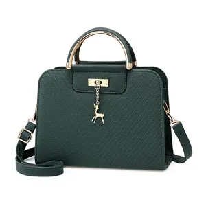 Donkergroene leren crossbody handtas voor dames met gouden hardware en schattig hertenhanger.