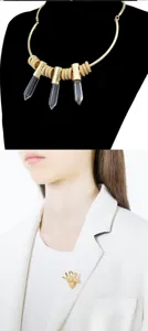 Goldfarbene Choker-Halskette mit Kristall-Säulen-Anhängern und stilvoller Buchstaben-Brosche.