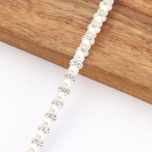 Detail view of DIY rhinestone and pearl trim strip for clothing and crafts accessories.