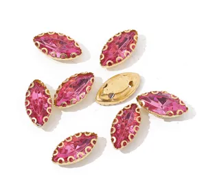 Close-up detail of pink marquise rhinestone with gold claw setting and back sewing holes.