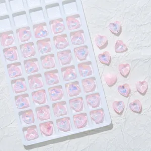 Rosa Herz Kristall Strasssteine Nahaufnahme, schimmernde Nailart Anhänger und DIY Handy Zubehör.