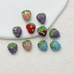 Detailed close-up of colorful rhinestone strawberry DIY charm beads with sparkling crystals.
