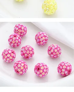 Detail view of colorful rhinestone loose beads with holes for DIY phone chains and craft keychains.