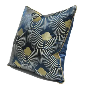 Gros plan détaillé du coussin à motif éventail bleu et or, soulignant les finitions élégantes.