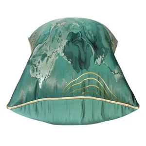 Gros plan de la housse de coussin décorative verte de luxe avec des motifs de lignes dorées.