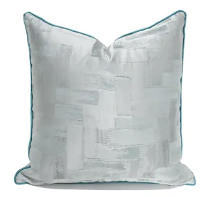 Modern silver grey geometric throw pillow with blue piping for sofa chair home decor.