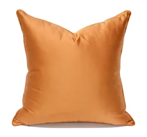 Fundas de cojín de satén naranja para sofá moderno, elegante detalle de decoración.