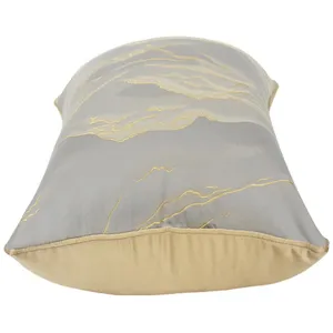 Detailaufnahme des modernen grau-goldenen, abstrakt bestickten Kissenbezugs fuer das Sofa.