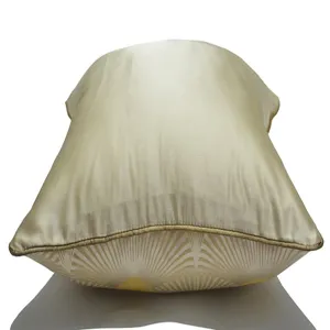 Funda de cojín para sofá en seda dorada clara con patrón de abanico art déco y ribete dorado.