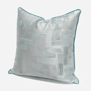 Silver gray geometric throw pillow with blue piping, modern sofa cushion for home decor.
