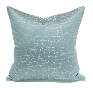 Close-up detail of modern blue-green throw pillow cover with elegant crackle texture.