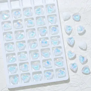 Nahaufnahme von schimmernden herzförmigen Kristall-Strasssteinen für Nagelkunst und DIY-Etuis.