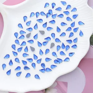 Gedetailleerd overzicht van blauwe druppelvormige glasstrassteentjes, platte hotfix kristallen.
