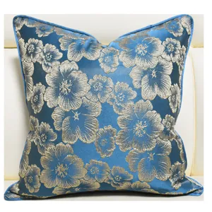 Elegant blue jacquard cushion cover with silver floral pattern for living room decor detail.