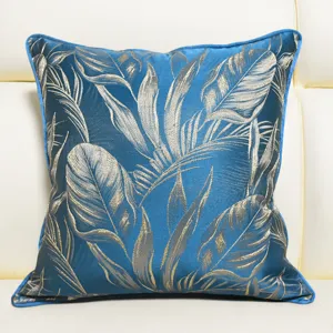 Detailed shot of luxury blue decorative pillow cover with gold botanical leaf jacquard pattern.