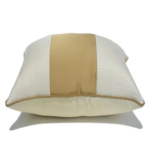 Vue de détail rapproché de la housse de coussin décorative beige et or au design moderne chic.