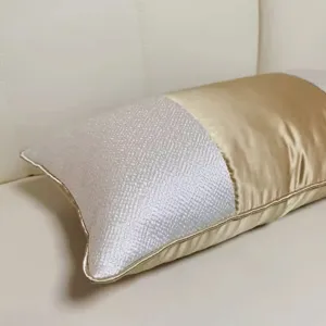 Housse de coussin décorative moderne et luxueuse or et blanc cassé pour canapé.
