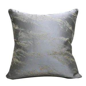 Close-up detail of luxury abstract jacquard cushion cover featuring gold textured fabric decor.