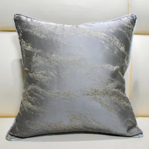 Close-up detail of grey decorative throw pillow featuring elegant abstract gold texture design.