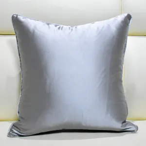 Detail shot of a grey square cushion pillow placed on a modern sofa for home decor.