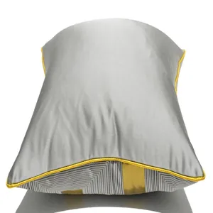 Grey luxury throw pillow detail showing modern geometric striped pattern and yellow piping.