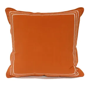 Housse de coussin en peluche orange avec bordure brodée à triple ligne blanche pour salon.