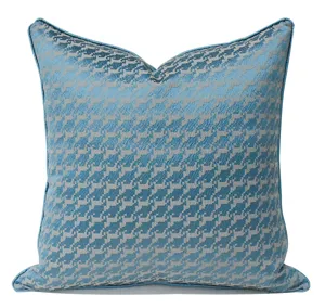 Blue houndstooth pillow cover detail, luxury decorative throw cushion fabric texture close up.