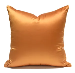 Solid orange satin square throw pillow cover, elegant living room home decor detail view.