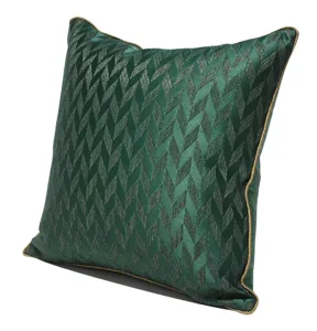 Dunkelgrüner geometrischer Kissenbezug mit goldenem Kantenband für moderne Sofadekoration.