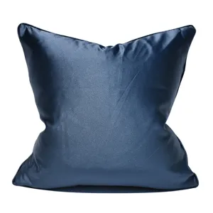 Primer plano detallado de una funda de cojín azul oscuro de satén con ribete elegante.