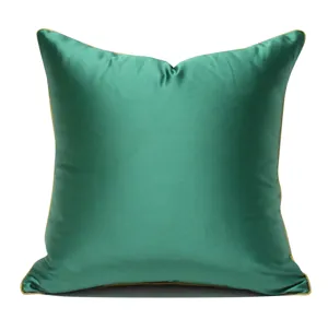 Grüner dekorativer quadratischer Kissenbezug mit goldenem Paspel für modernes Sofa.