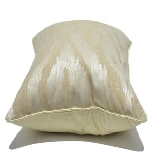 Vue détaillée de la housse de coussin rayée abstraite crème, texture et passepoil.