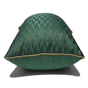 Detailansicht des grünen Kissenbezugs mit geometrischem Chevron-Muster und Goldpaspel.