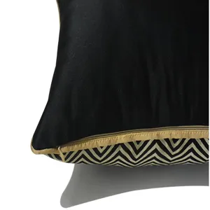Close-up view of black satin and gold chevron pattern cushion cover edge and zipper detail.