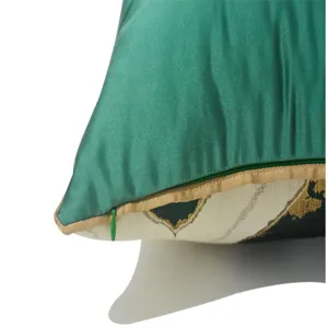 Green silk throw pillow cover detail shot showing luxury gold piping and geometric pattern.