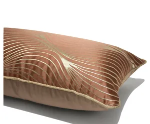 Vista dettagliata di un cuscino lombare marrone di lusso con eleganti motivi geometrici dorati.