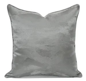 Detailed close-up of a luxury silver-grey velvet cushion cover with elegant curved shape.