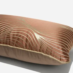 Cuscino decorativo rettangolare di lusso con righe geometriche dorate e raso marrone divano.