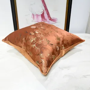 Elegante fodera per cuscino arancione di lusso moderno con ricamo di foglie di ginkgo.