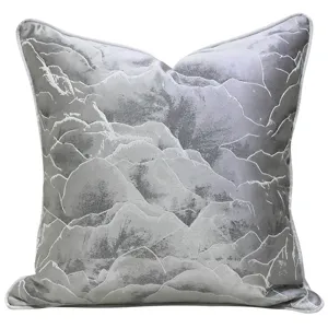 Modern light gray throw pillow with abstract mountain pattern and white piping for sofa decor