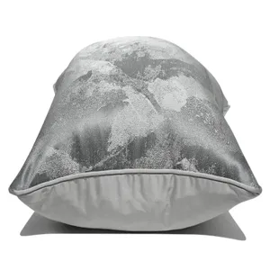 Housse de coussin motif abstrait gris en détail, gros plan sur la texture du tissu.