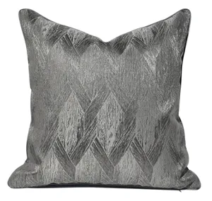 Cuscino decorativo grigio scuro strutturato con motivo geometrico metallico dettaglio divano.