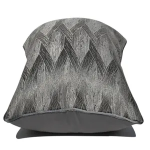 Primo piano dettagliato del morbido cuscino grigio scuro con trama geometrica tessuta.