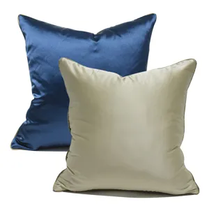 Close-up detail of blue and beige satin cushion covers with piping edge for home decor.