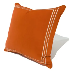 housse de coussin orange brodee vue de detail avec bordure decorative blanche et chic